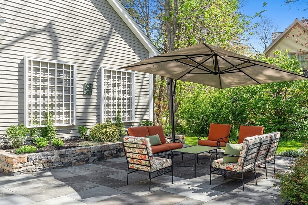 537 Barretts Mill Road Concord, MA 01742 - Photo 31 of 35 a patio with a patio table and chairs under an umbrella