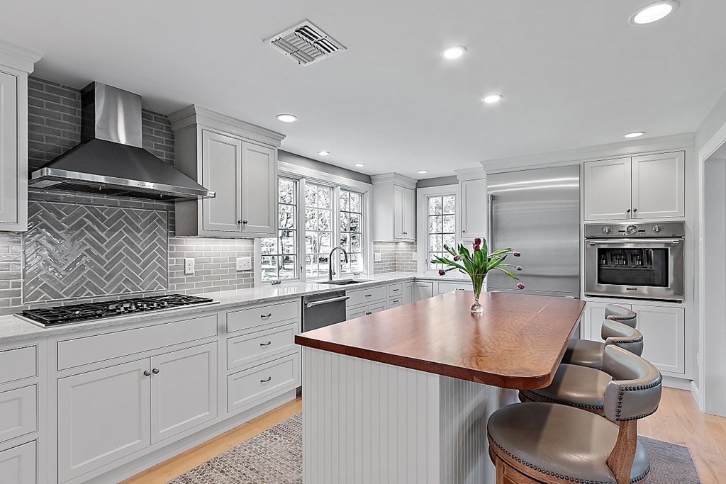537 Barretts Mill Road Concord, MA 01742 - Photo 10 of 35 a kitchen with stainless steel appliances granite countertop a sink a stove and a refrigerator
