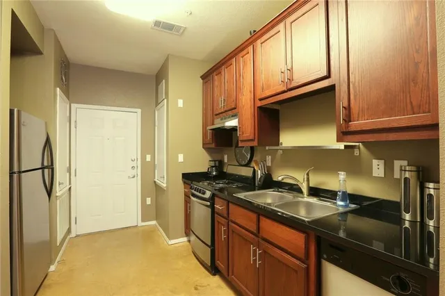 a kitchen with stainless steel appliances granite countertop a sink stove and refrigerator