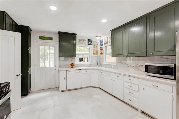 a kitchen with granite countertop white cabinets and white appliances
