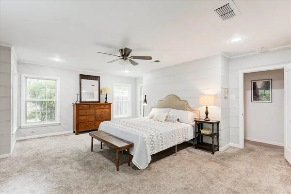 a spacious bedroom with a bed and a chandelier