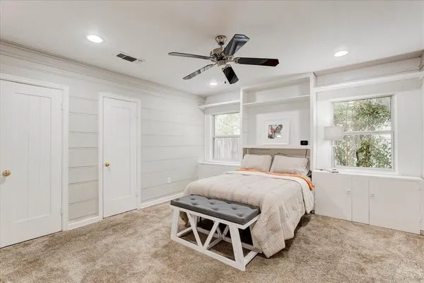 a bedroom with a bed a window and a chandelier