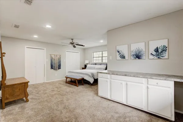 a spacious bedroom with a bed and a cabinets