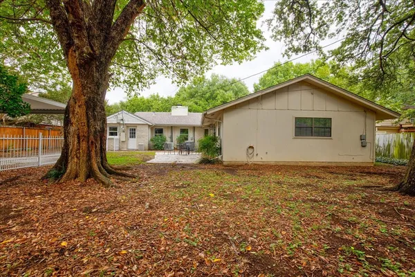 a view of house with backyard and trees