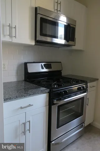 a kitchen with stainless steel appliances granite countertop a stove microwave and sink