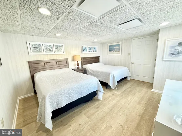 a bedroom with two beds and painting on the wall
