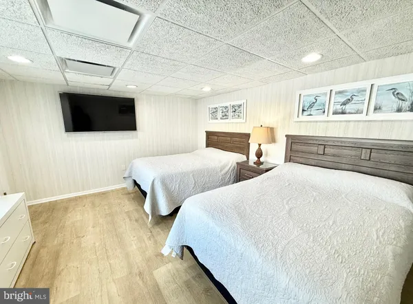 a bedroom with two beds and a flat screen tv