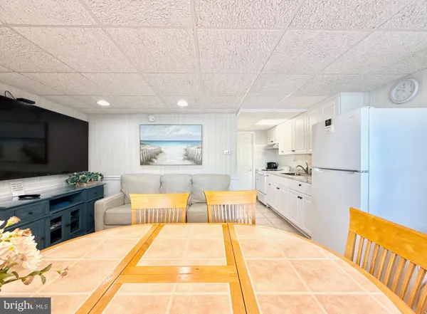 a large room with stainless steel appliances kitchen island granite countertop a refrigerator stove top oven and sink