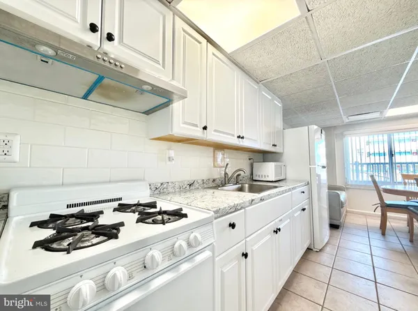 a kitchen with a sink a stove and chairs