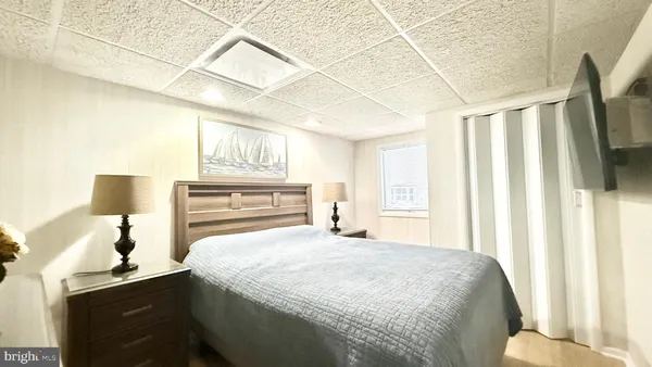 a bedroom with a bed and a lamp on the dresser