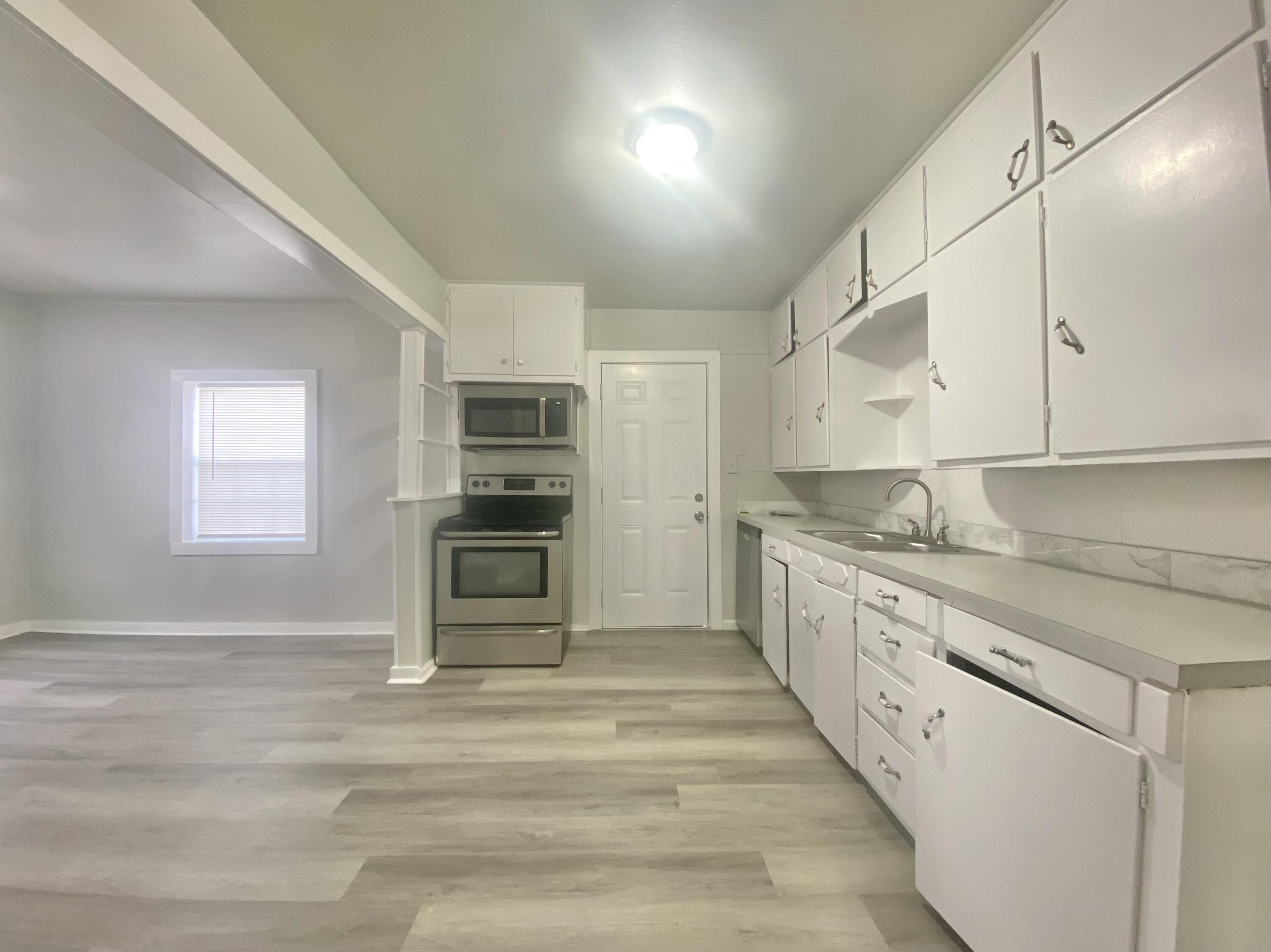 5701 45th Street Lubbock, TX 79414 - Photo 5 of 12 a large kitchen with granite countertop a stove and a sink