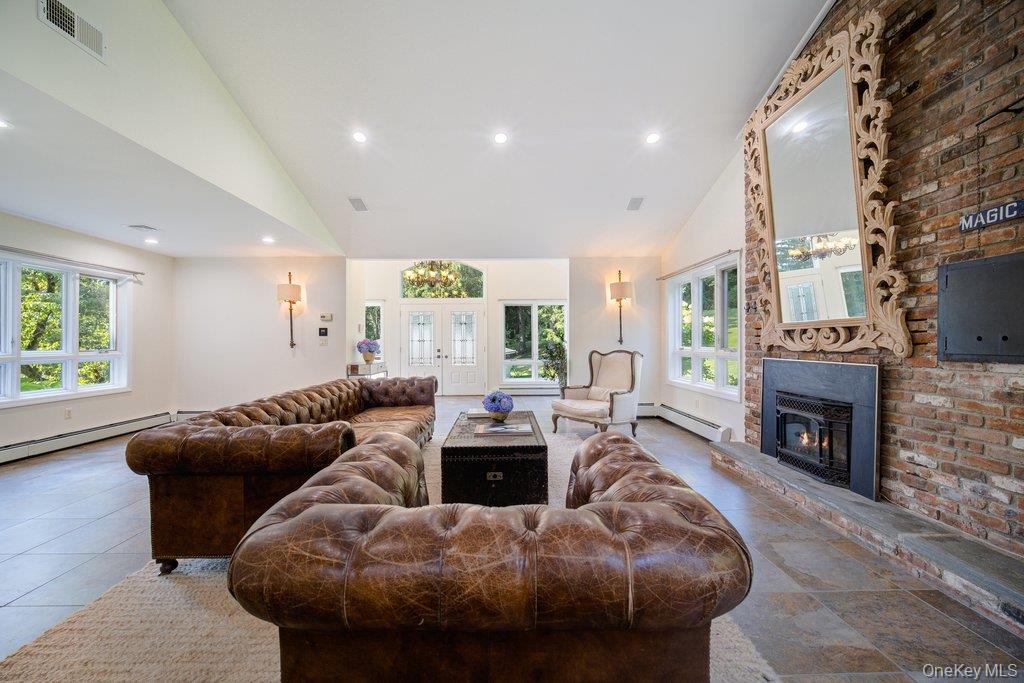 237 Mineral Springs Road Highland Mills, NY 10930 - Photo 11 of 32 a living room with furniture a fireplace and a floor to ceiling window