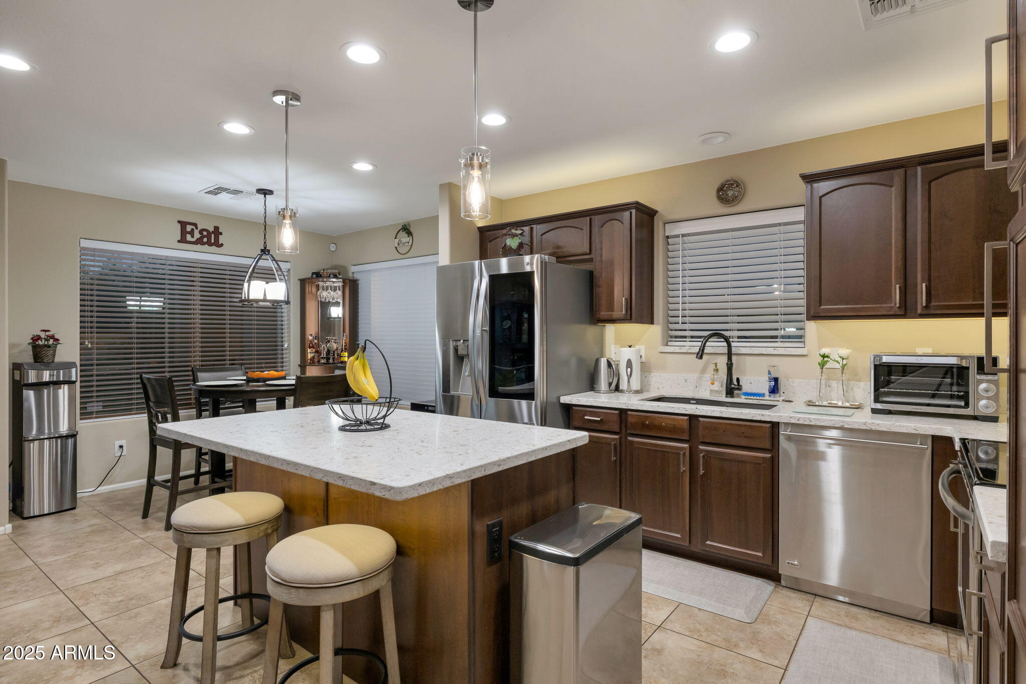 a kitchen with granite countertop kitchen island stainless steel appliances a sink stove and refrigerator