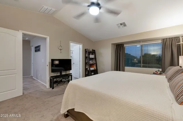 a bedroom with a bed and a flat tv screen on dresser