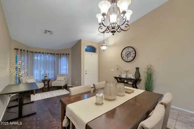 a view of a dining room with furniture and a chandelier fan