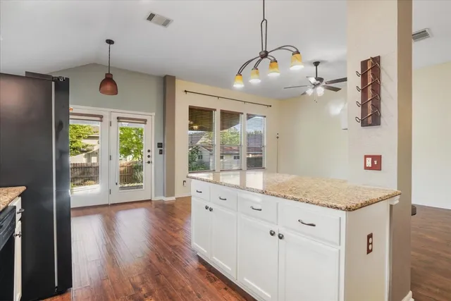 a open kitchen with granite countertop a stove a sink and dishwasher with wooden floor