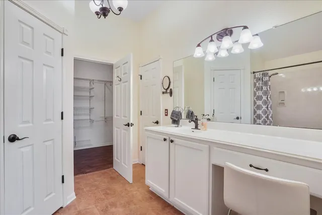 a spacious bathroom with a sink a large mirror and a shower