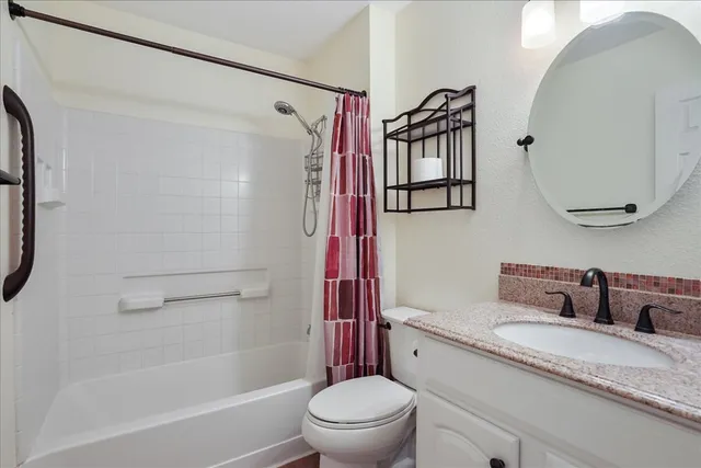 a bathroom with a granite countertop sink toilet and shower