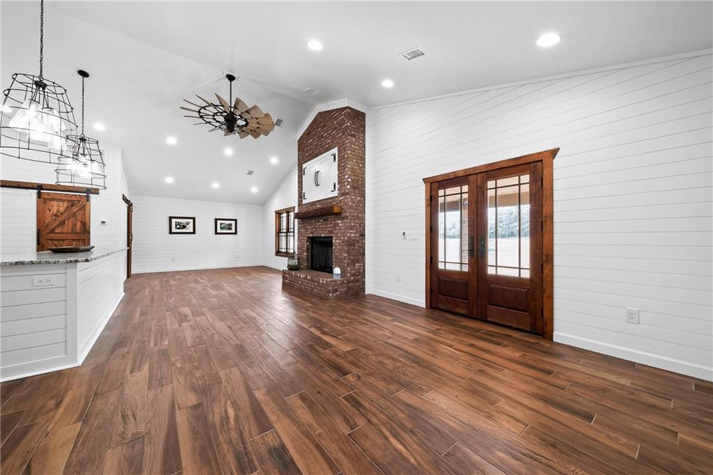 611 Padgetts Road Opelika, AL 36804 - Photo 47 of 64 Vaulted ceiling, wood-finish flooring, white shiplap walls, brick fireplace, and double French doors