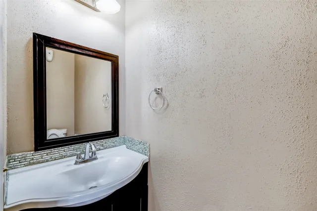 a view of an empty room with window and chandelier fan