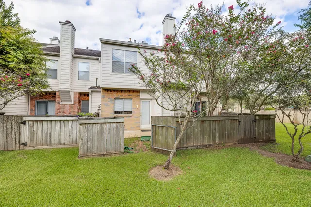 a view of a house with a yard and wooden fence