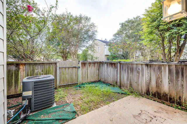 a view of a house with a yard and a large tree