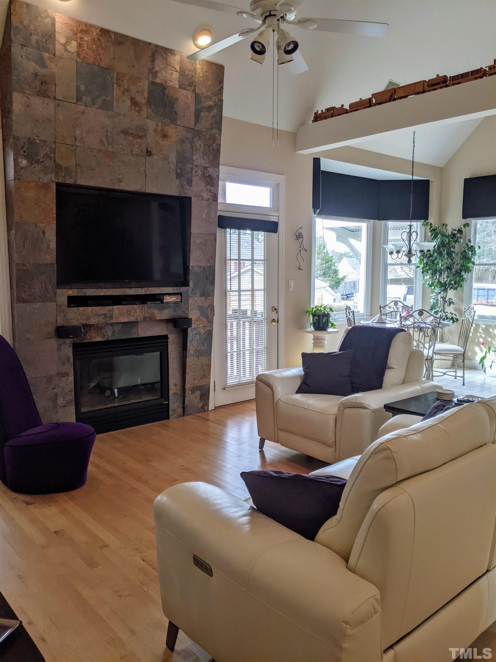 2405 Andor Place Raleigh, NC 27604 - Photo 4 of 30 a living room with furniture a flat screen tv and a fireplace