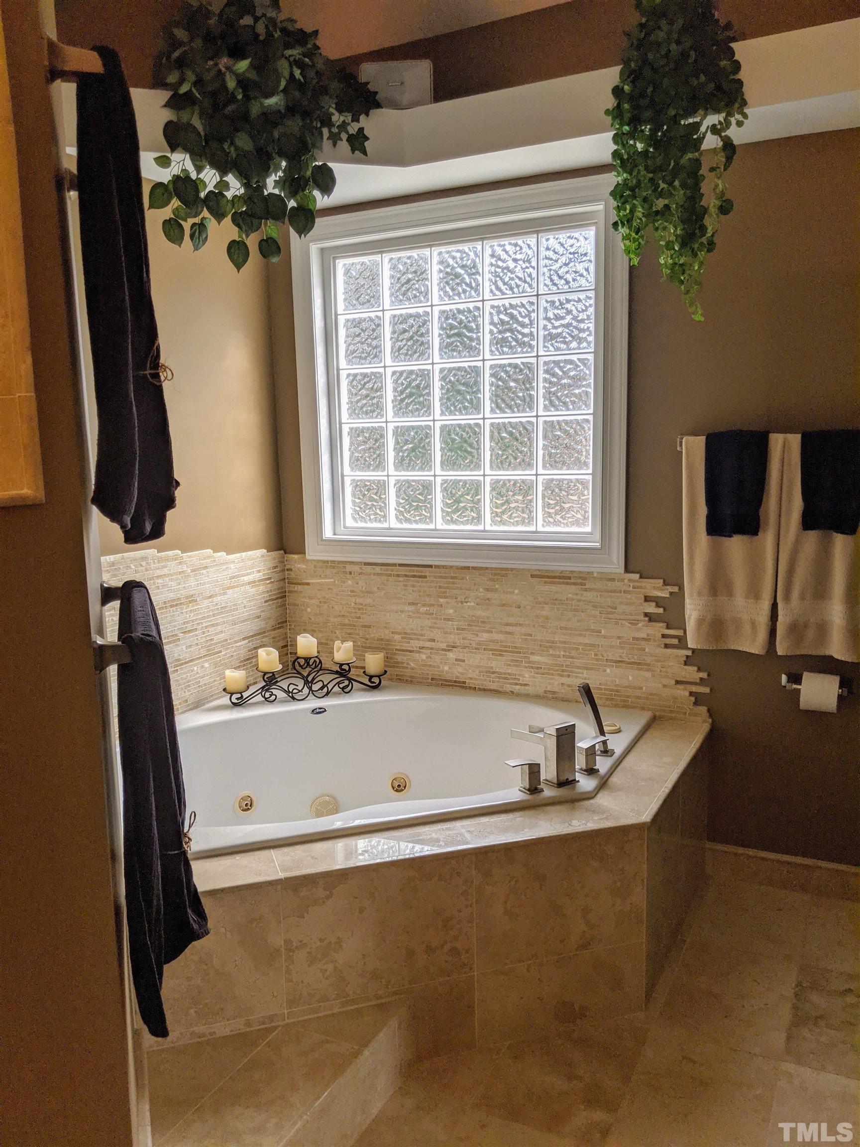 2405 Andor Place Raleigh, NC 27604 - Photo 9 of 30 a bath tub sitting in a bathroom next to a window