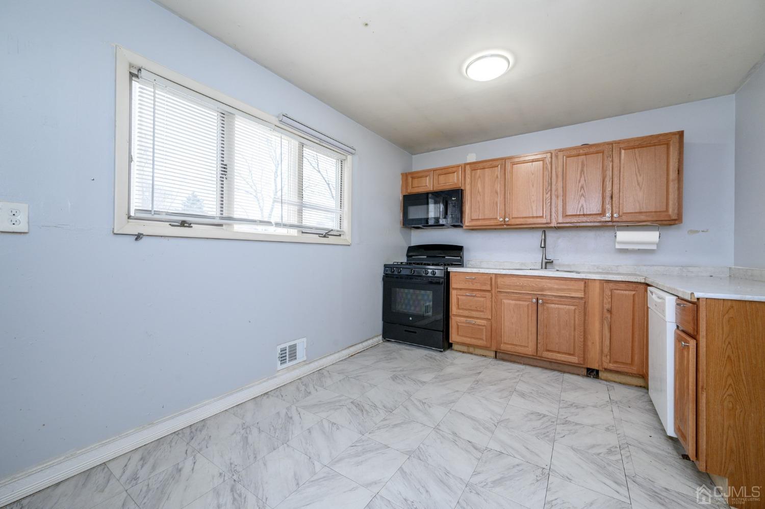 186 Central Avenue Edison, NJ 08817 - Photo 10 of 32 a kitchen with a stove a sink and a window