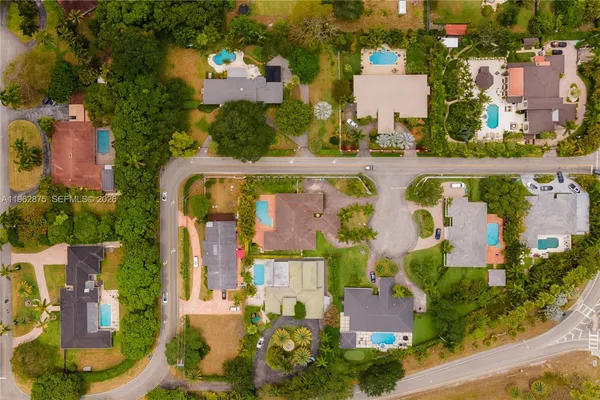 an aerial view of residential houses with outdoor space and parking