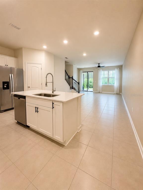 339 Redbud Road Palm Coast, FL 32137 - Photo 5 of 22 a kitchen with stainless steel appliances a sink a stove a refrigerator cabinets and living room view