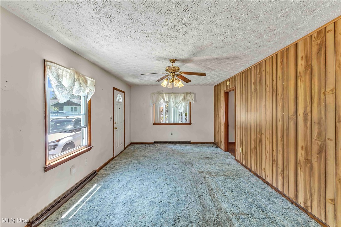 321 Overlook Road Vermilion, OH 44089 - Photo 13 of 27 Living Room featuring ceiling fan, carpet flooring, a textured ceiling. Hardwood Floors Under Carpeting.