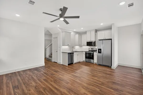 a kitchen with a refrigerator and white cabinets