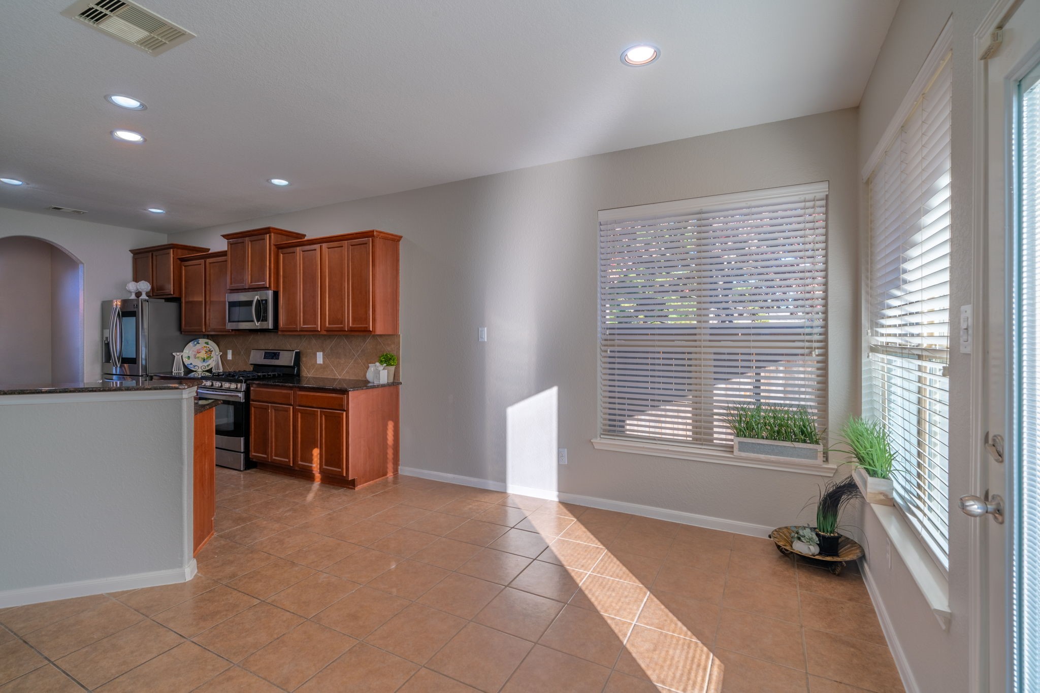 138 Magnolia Grove Lane Conroe, TX 77384 - Photo 17 of 43 a kitchen with kitchen island granite countertop a stove a sink a refrigerator and a cabinets
