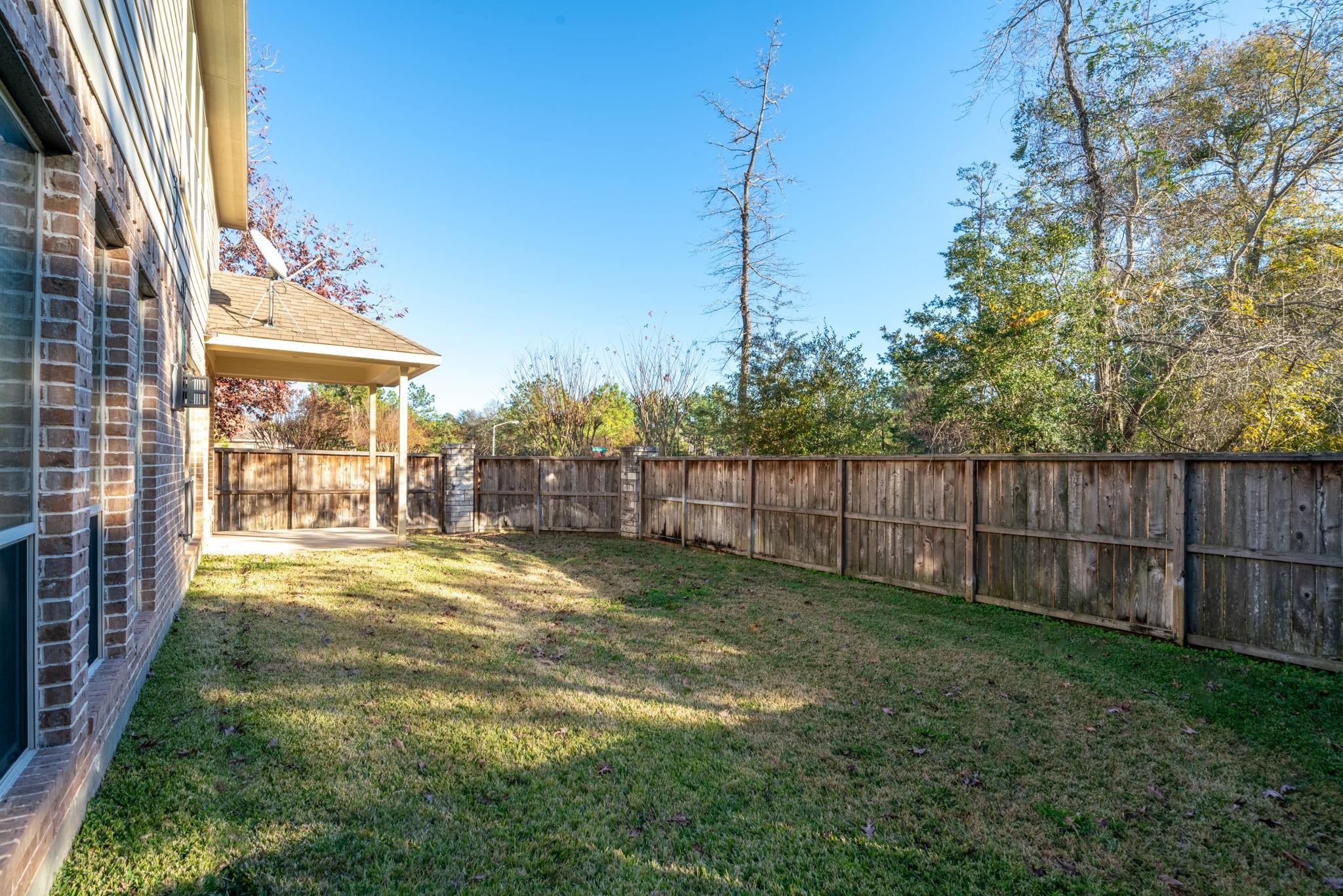 138 Magnolia Grove Lane Conroe, TX 77384 - Photo 42 of 43 a view of a backyard with floor to ceiling window and wooden fence