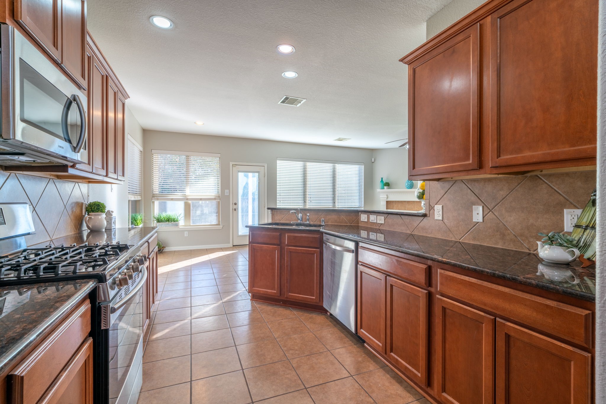 138 Magnolia Grove Lane Conroe, TX 77384 - Photo 8 of 43 a kitchen with stainless steel appliances granite countertop a stove a sink and a microwave