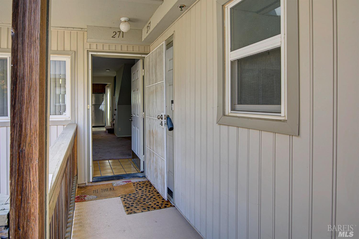 a view of a hallway with a hardwood and door