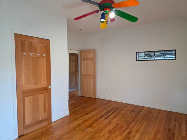 a view of an empty room with wooden floor and entryway