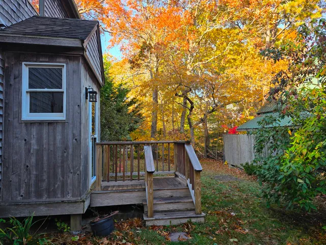 a view of wooden house with a small yard