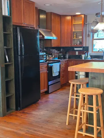 a kitchen with stainless steel appliances granite countertop a refrigerator and a stove