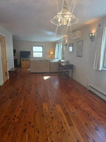 a view of a livingroom with furniture wooden floor and chandelier