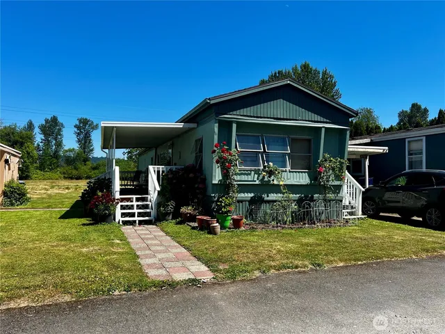 a view of a house with backyard and porch