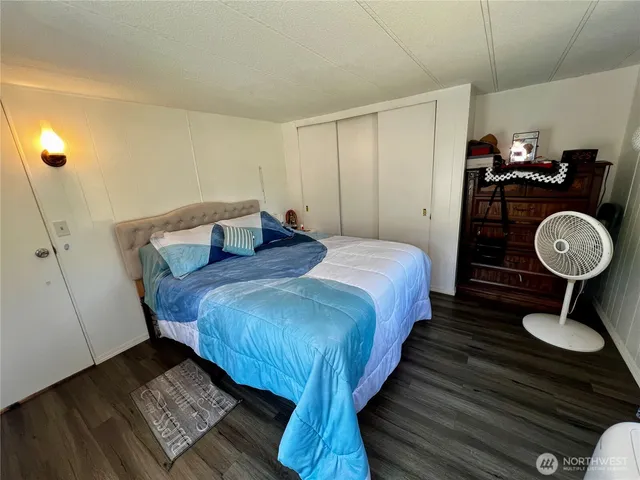 a bedroom with a bed wooden floor and window
