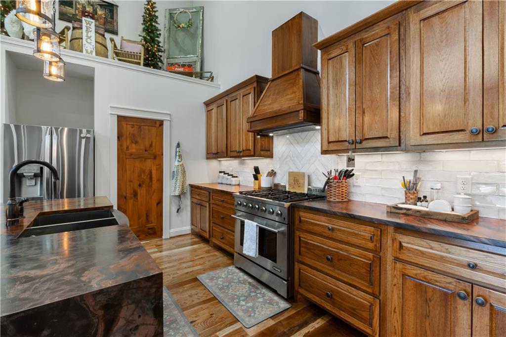 1590 4 Mile Church Road Ball Ground, GA 30107 - Photo 25 of 65 a kitchen with granite countertop a stove top oven a sink dishwasher and cabinets with wooden floor