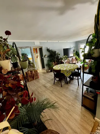 a living room with patio furniture and a wooden floor