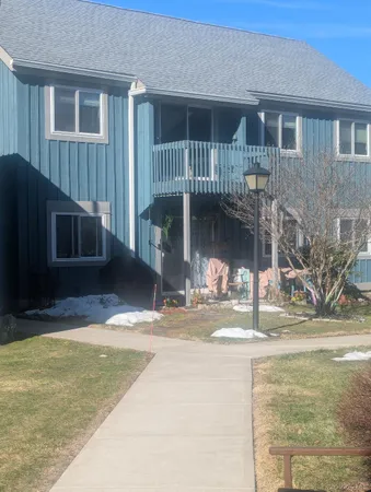 a view of a house with a patio and a yard
