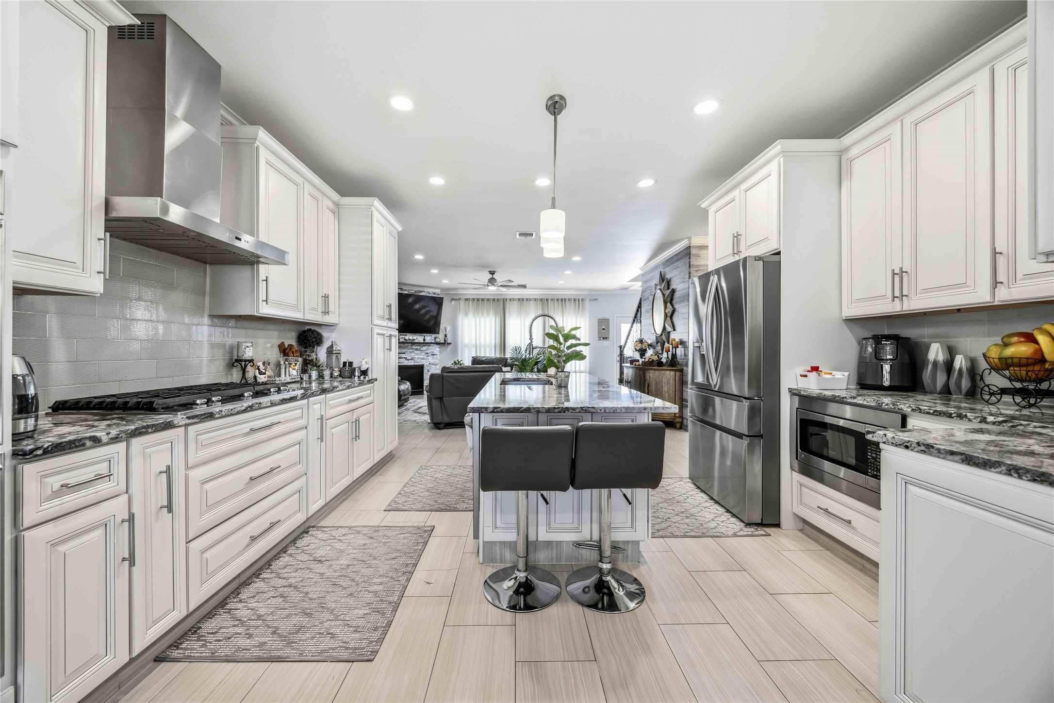 19219 Brook Village Road Houston, TX 77084 - Photo 3 of 29 a kitchen with stainless steel appliances kitchen island granite countertop a refrigerator oven a sink a stove and white cabinets