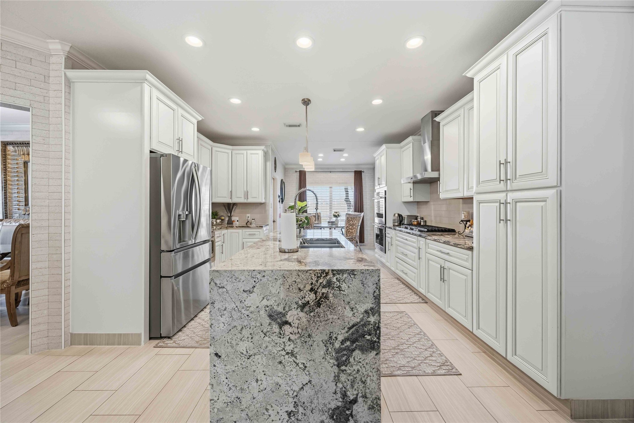 19219 Brook Village Road Houston, TX 77084 - Photo 6 of 29 a large kitchen with stainless steel appliances kitchen island granite countertop a refrigerator and a stove top oven