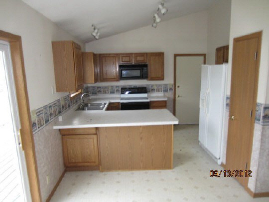 12951 Holverson Road Durand, IL 61024 - Photo 4 of 11 a kitchen with a stove a refrigerator and a sink