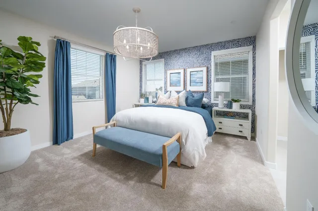 a spacious bedroom with a bed and a potted plant